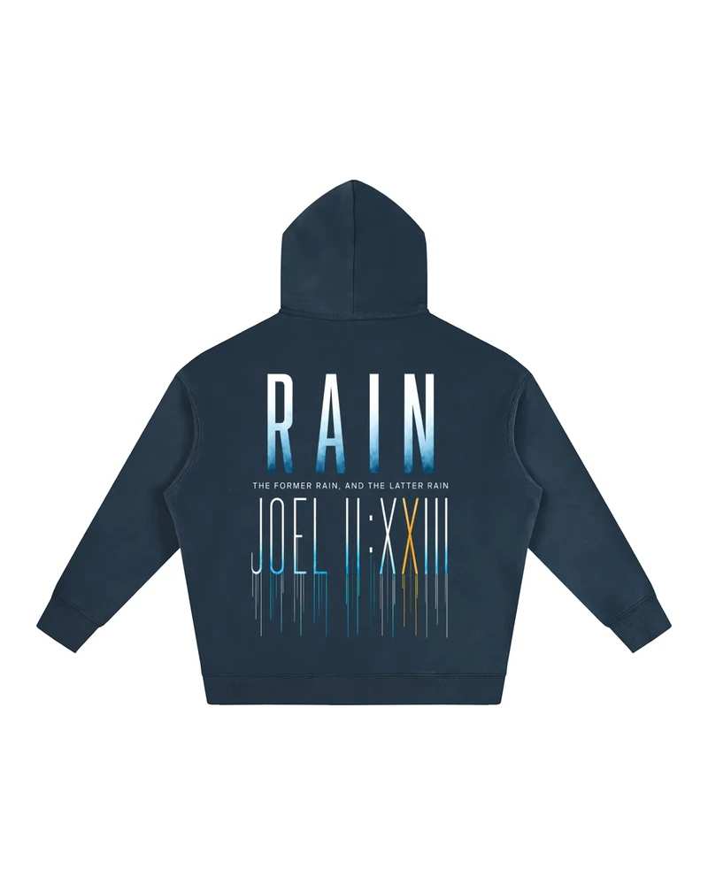 A mockup of the RAIN fleece hoodie in navy, from the back: RAIN in tall letters shading from white to blue, the words “The former rain, and the latter rain”, and Joel 2:23 in Roman numerals beneath, its strokes running down like rain.