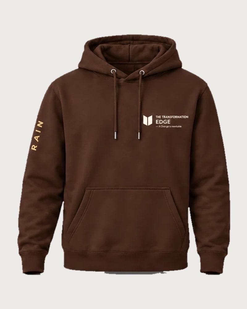 A mockup of the RAIN hooded jumper in chocolate, from the front: The Transformation Edge mark on the chest and RAIN down one sleeve.