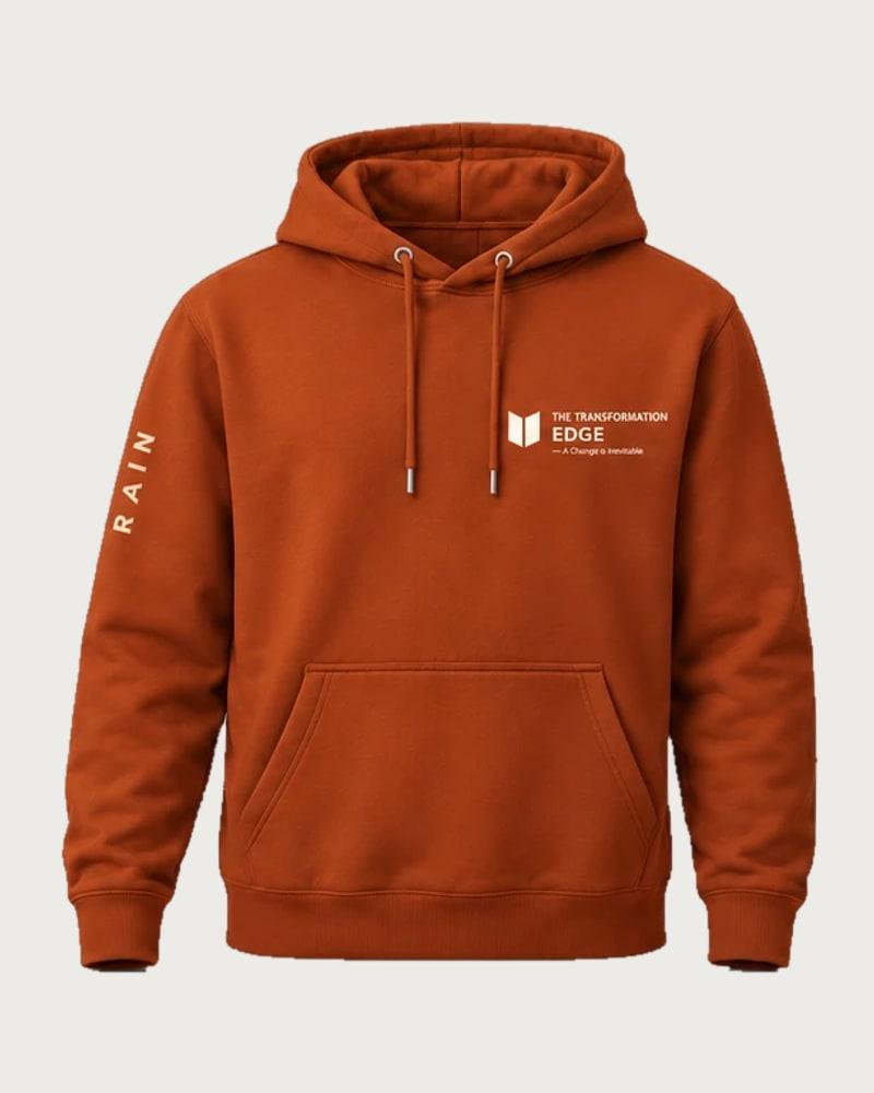 A mockup of the RAIN hooded jumper in rust, from the front: The Transformation Edge mark on the chest and RAIN down one sleeve.