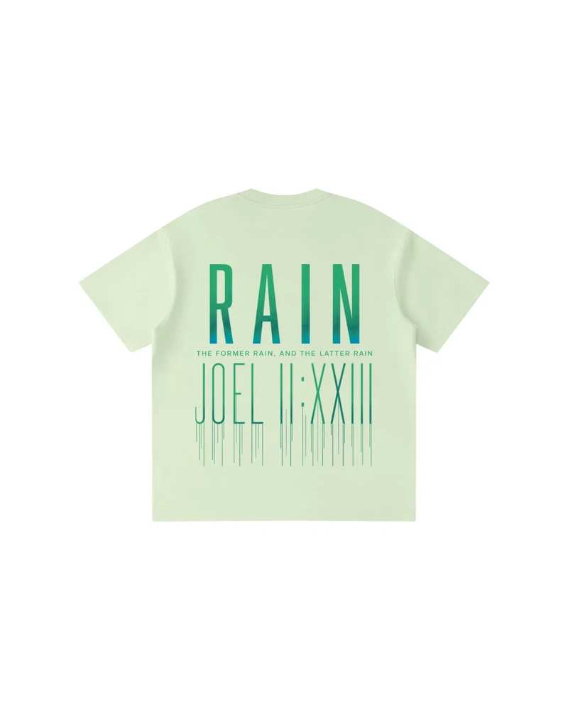 A mockup of the RAIN kids' t-shirt in green, from the back: RAIN in tall letters shading from green to white, the words “The former rain, and the latter rain”, and Joel 2:23 in Roman numerals beneath, its strokes running down like rain.