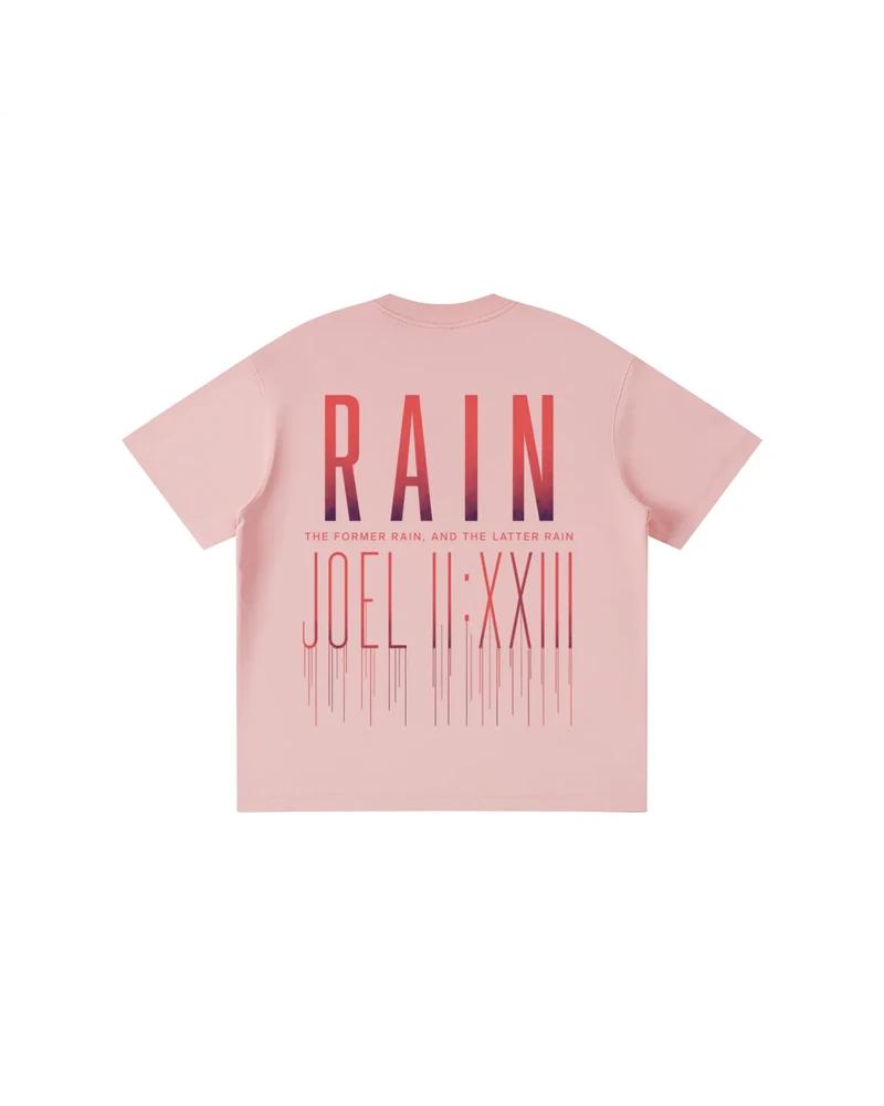 A mockup of the RAIN kids' t-shirt in pink, from the back: RAIN in tall letters shading from red to pink, the words “The former rain, and the latter rain”, and Joel 2:23 in Roman numerals beneath, its strokes running down like rain.