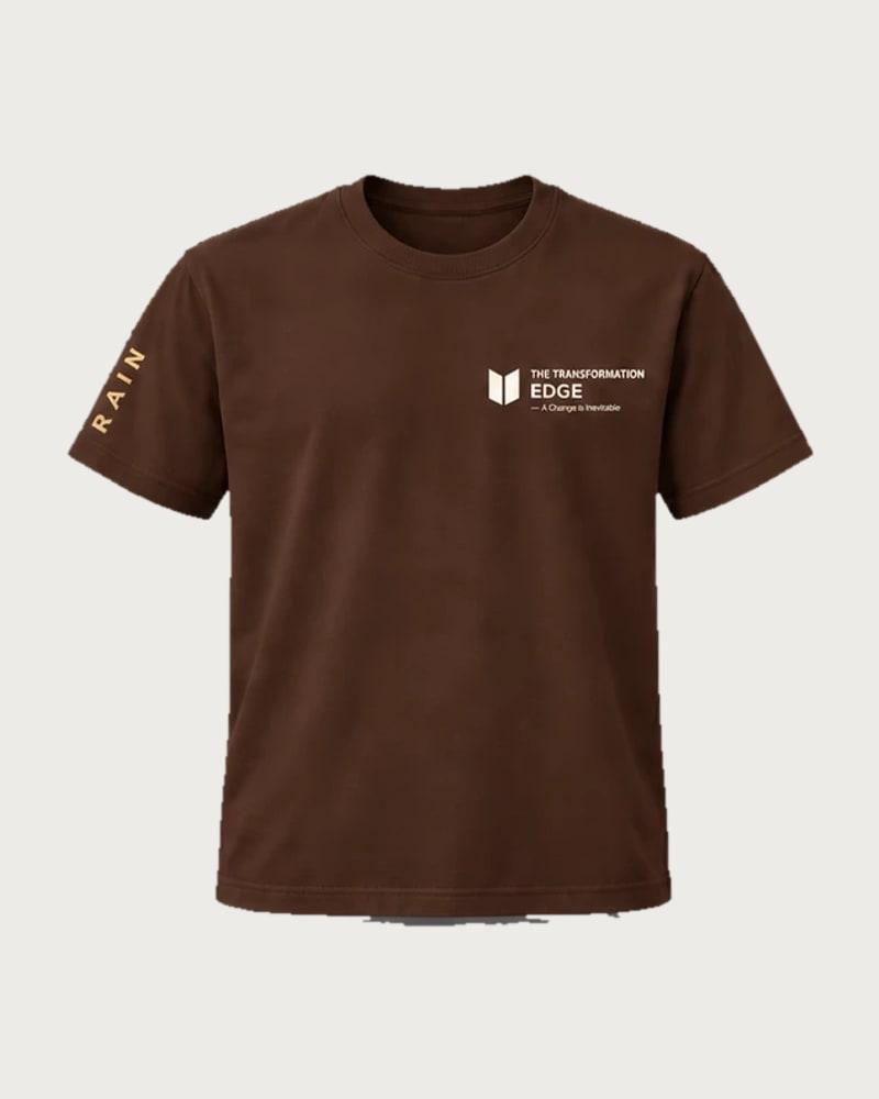 A mockup of the RAIN t-shirt in chocolate, from the front: The Transformation Edge mark on the chest and RAIN down one sleeve.
